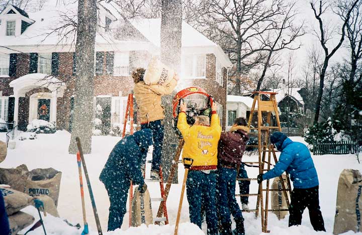 Members of the production crew sprinkle potato flakes into a fan to emulate snow on location in  Winnetka.