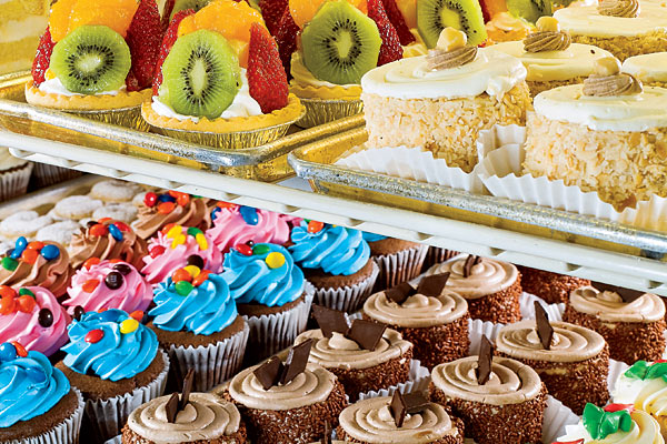 Trays of deserts; cupcakes, tarts, and other pastries