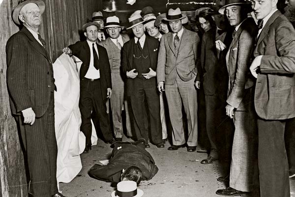Camera-conscious onlookers gather around Lingle’s prostrate corpse at the scene of the murder.
