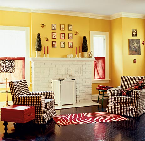 In Glen Ellyn, primary colors make a statement in a sparsely furnished sitting room. A wood floor painted black provides a streamlined foundation (no wood grain to interfere with the color scheme), a white-painted fireplace takes center stage, and an edited mix of bold color-on-white fabrics seals the deal.