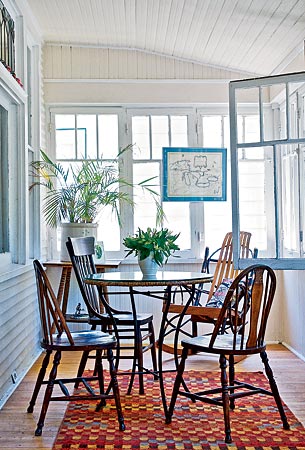 In this Oak Park bungalow, Kelly + Olive rearranged the owners' existing furniture and accessories. On the enclosed front porch, the redesigners made a defined dining area and hung an old map from a window frame.