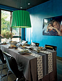 The dining room, painted a rich blue, and handmade tableware