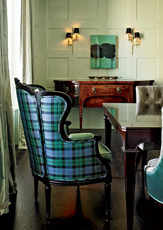 A wingback chair, with black lacquered frame, covered in silk tartan.