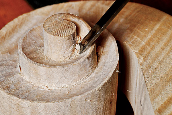A violin scroll being carved.