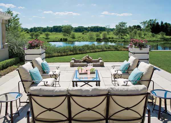 This seating area has a fire pit and a vista of the nature preserve on the other side of the pond. Furnish­ings were kept simple so as not to distract from the view.  