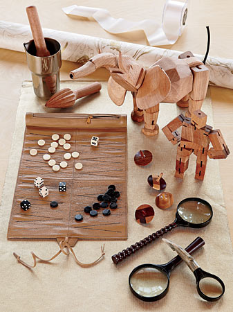 Three-piece cocktail set (aluminum shaker, wood muddler and juicer), handmade wooden tops from Original Tree Swing Company, leather travel backgammon set, flex-jointed wooden elephant, Cubebot by David Weeks Studio, and magnifying glasses with bone and wooden handles
