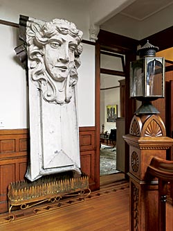 Presiding over the foyer is a nine-foot-tall architectural ornament hung over an antique jardinière. 