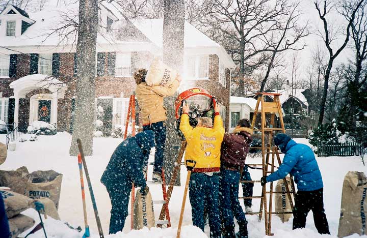 Members of the production crew sprinkle potato flakes into a fan to emulate snow on location in  Winnetka.