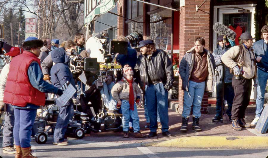 Culkin and the crew on location in Winnetka. Director Chris Columbus stands in front of the brick pillar; cinematographer Julio Macat is on Culkin’s left. 