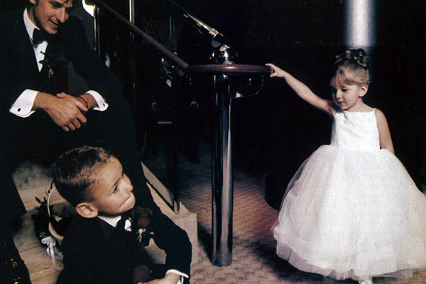 Clad in the "princess dress" she had picked out to wear at her uncle's wedding, Riley waits with her brother and father prior to the ceremony at Holy Name Cathedral. A few weeks later, she would be buried in the same dress.