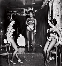 The jazz and blues singer Ernestine Anderson (center), clad in hip-hop regalia, serenades a pair of Bunnies at the Playboy Club in 1962