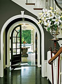 The backyard pool is visible from the front entry, framed by French doors.