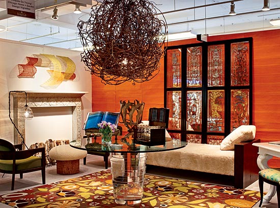 Edelmann used an 18th-century English mantel to create instant intimacy for her library/lounge and a contemporary rug from Atelier Lapchi to establish a vibrant, unpredictable point of view. The orange hand-stitched paper wallcovering by Maya Romanoff “created a happiness and made people want to come in,” she says.