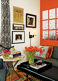 In the guest bedroom/TV room (below), a bright orange accent wall sets off an armless charcoal sofa, black-and-white draperies, and a leather-topped bench that serves as a coffee table.