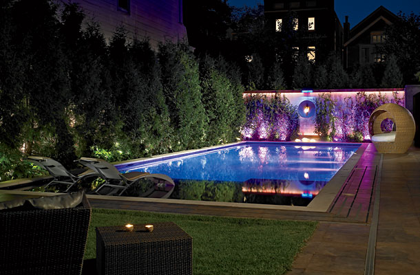 Illuminated polyethylene rocks (lit from within with incandescent bulbs, available at Lightology) provide a moody glow poolside, while a cozy wicker womb chair provides room to chill.