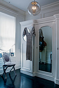 Old World references make this home romantic. The dressing room, with its curvy 18th-century-style French chair and freestanding antique wardrobe, is a throwback to a time before built-in closets were the norm.