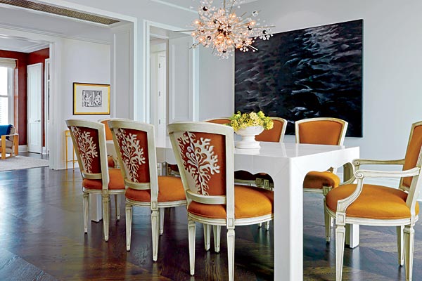 Embroidered fabric on chair backs, an oversized herringbone pattern in the wood floor, and a custom-made table sheathed in parchment lend quirky elegance to the dining room. The Met chandelier is by Lobmeyr, the painting is by Karen Gunderson, a nod to the home’s view of Lake Michigan.