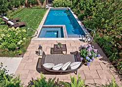 A hot tub is set inside the pool; these and other rectilinear components of the landscape design are arranged like boxes inside larger boxes. The furniture, made with synthetic fiber caning, was selected by Tom Stringer Design Partners from Janus et Cie.