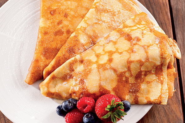 Crepes with powdered sugar, strawberries, raspberries and blueberries