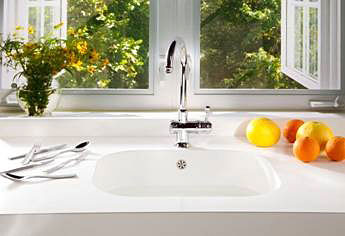 A white Silestone sink with fruit sitting next to it.