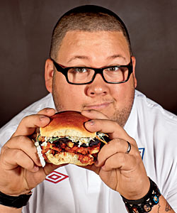 Chef Graham Elliot Bowles, eating a pork belly sandwich