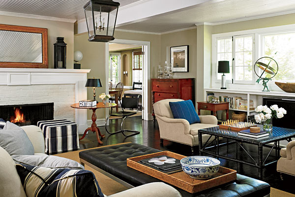In the living room, Ralph Lauren club chairs face each other near the TV or join the cozy seating area in front of the fireplace, where an upholstered bench serves as a coffee table.
