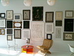 A sunlit room decorated with various drawings and other art