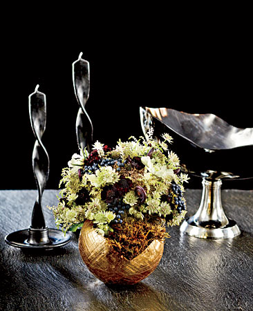 A Frances Stoia variegated horn bowl on a silver-plated base, waterproof papier-mâché urn from Up in the Air and flowers, handmade ceramic candleholders, and twisted beeswax candles