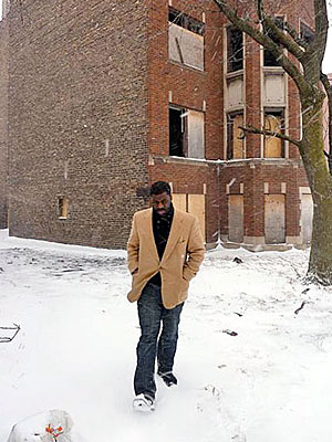 Alderman hopeful Che 'Rhymefest' Smith in front of one of the many boarded-up buildings in the 20th Ward