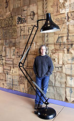 Stuart Grannen, owner of Architectural Artifacts, posing behind an oversized lamp