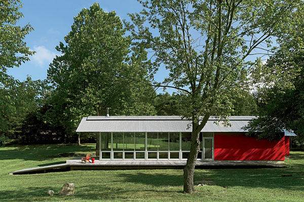 Floor-to-ceiling windows are all about enjoying the rural Indiana landscape. The loading ramps of old barns inspired the “boardwalk” running alongside the house. “It rolls up from the ground without steps and rolls back down—pulling you out into the hills,” says architect Mark Weber.