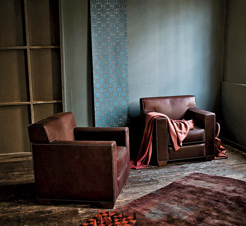 Jean-Michel Frank’s Confortable club chairs with a rug, cashmere throw, chess set, and wallpaper display from the Maison collection. 