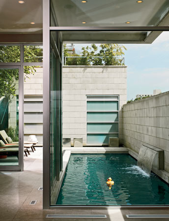 A small waterfall in the pool area adds soothing noise; a narrow koi pond, complete with gas-fed fire cubes, runs along the wall of the garage.