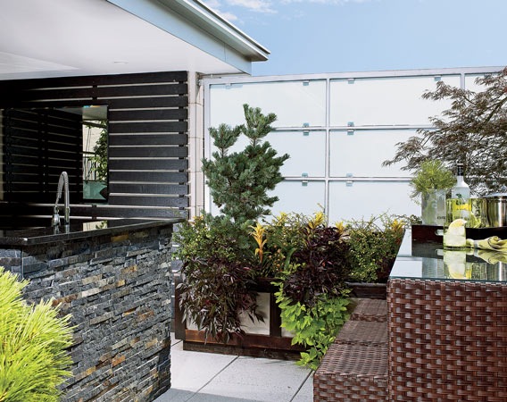 Outdoor kitchen island clad in cleft slate and topped with Black Galaxy granite.