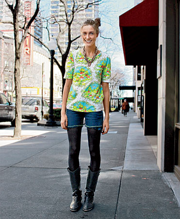 Fashion designer Morgan Carr wearing a brightly colored print shirt, jean shorts, dark tights, and boots