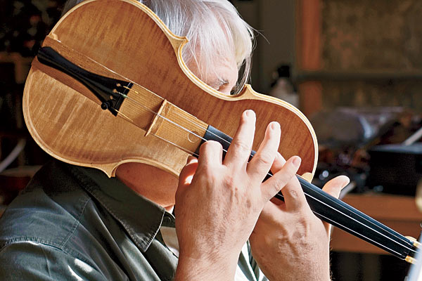 Meineke listening to a disassembled violin