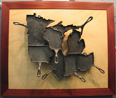 An art piece by Alisa Toninato, featuring cast-iron pans remolded into Midwestern states