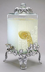A lemonade pitcher made of silver and glass