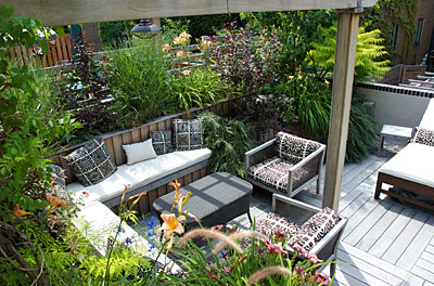 A furnished deck surrounded by a garden