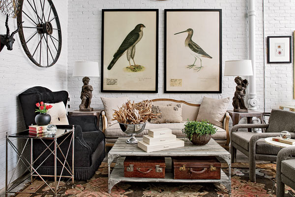 Large bird prints make for a striking focal point in this vignette, where an oversize traditional wing chair is balanced by a pair of smaller modern chairs.  