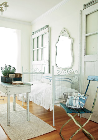 The owner of this newly built home made these two rooms feel old by adding an iron daybed, worn painted-wood pieces, and other countryish elements. 