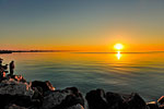 A man fishing on a lake at sunset