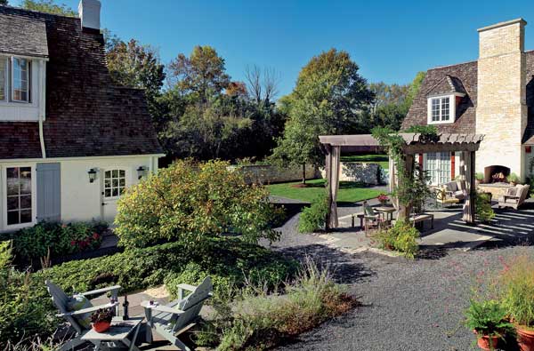 The courtyard, complete with an outdoor fireplace, is perfect for both cocktail parties and intimate chats on a pair of Adirondack chairs. The building to the right houses Ponterio's office.