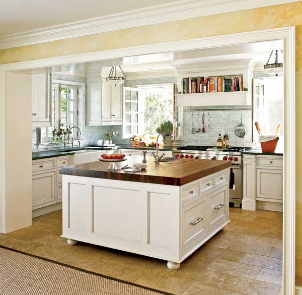 The kitchen features Christopher Peacock cabinetry, walls tiled with Carrara marble, and soapstone countertops. 