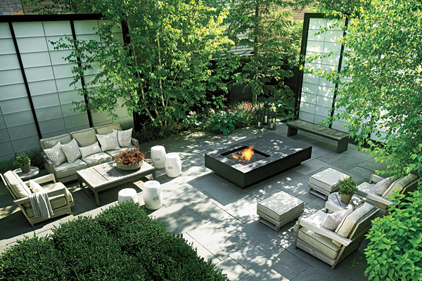 Grouped seating in a neutral palette, Chinese garden stools, shoji-inspired screens, bluestone pavers, and a sleekly modern fire pit make the side yard a serene space.