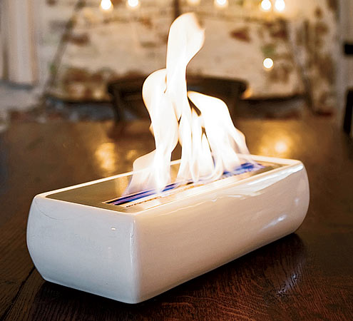 Avani’s portable fireplace includes a ceramic shell, a stainless steel burner, a control wand, a spout for fuel, and a long lighter