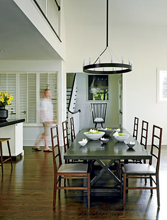 The familiar yet modern form of ladder-back BDDW chairs around the Crate & Barrel table in this Saugatuck Cape Cod is perfectly in line with the aesthetic of the rest of the house.