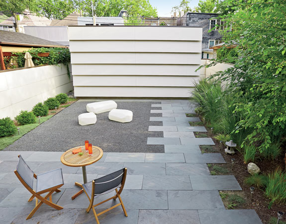 By using the same material for the fence and garage, Wheeler created an outdoor room with simple white walls. 