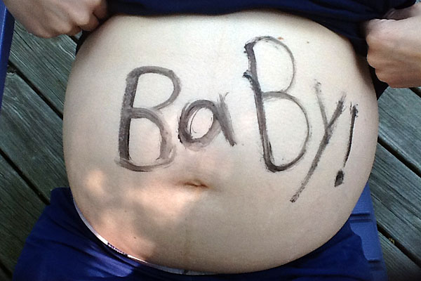 A pregnant belly with 'Baby!' written on it