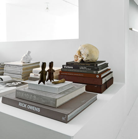 Design books, magazines, and sculptural objects, including a human skull, occupy a ledge in Machnik's office